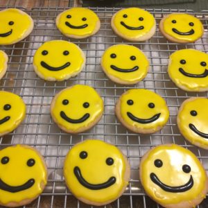photo of iced cutout cookies with smiley faces from cocos confections